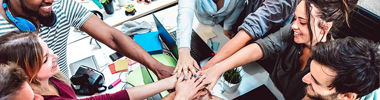 hands stacked by happy coworkers while working in an office