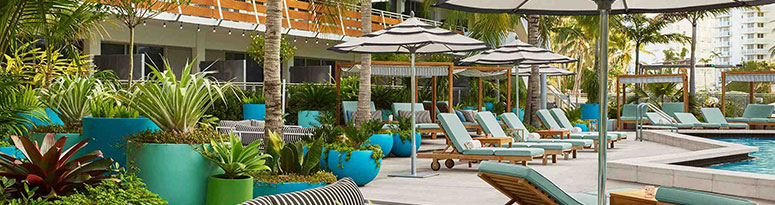 large outdoor planters decorate a pool deck near a luxury oceanfront resort